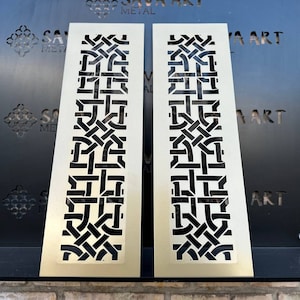 May include: Two gold metal panels with a geometric pattern cut out. The panels are mounted on a black metal shelf. The text "SAVA ART METAL" is visible on the shelf.