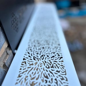 May include: White metal vent cover with a decorative cutout design resembling a coral reef. The design is intricate and detailed, creating a delicate and airy look.