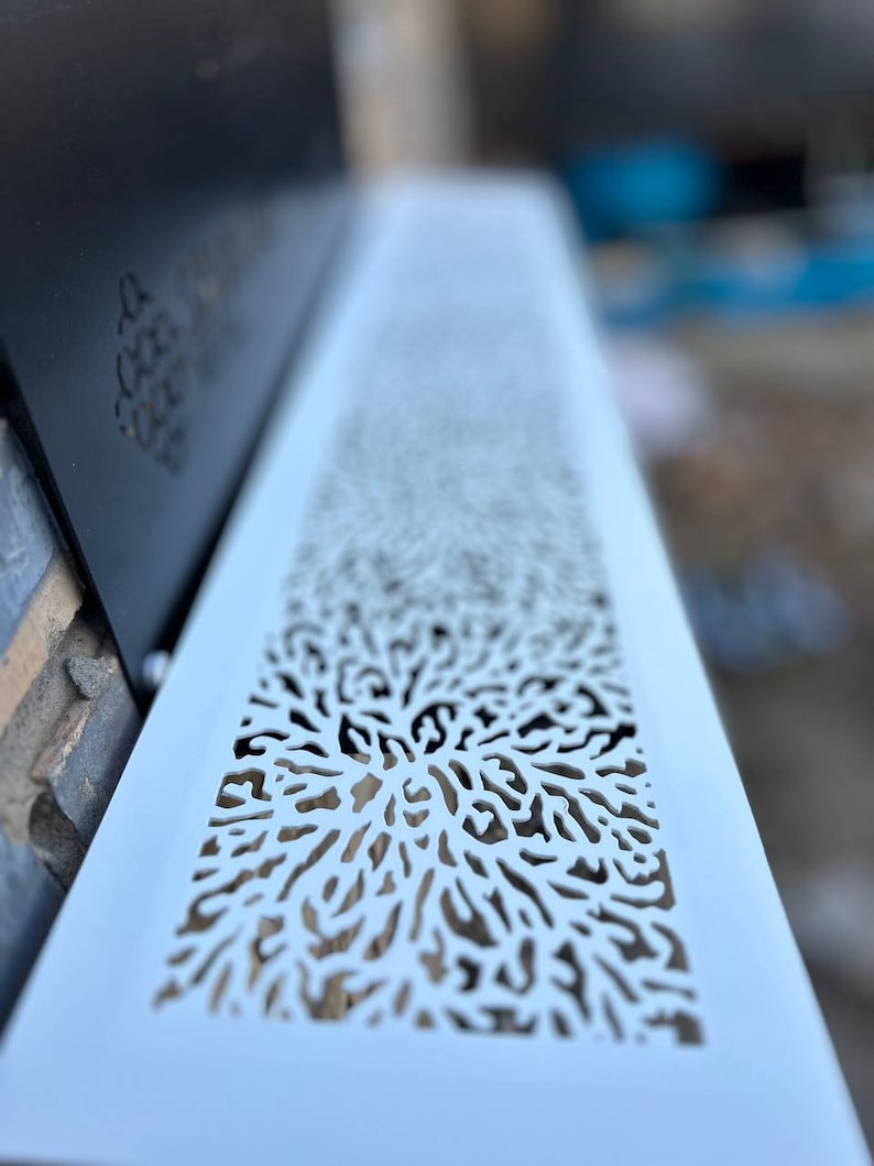 May include: White metal vent cover with a decorative cutout design resembling a coral reef. The design is intricate and detailed, creating a delicate and airy look.