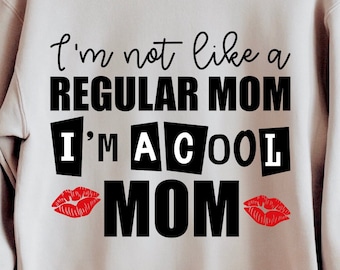 May include: A light gray sweatshirt with the text "I'm not like a regular mom I'm a cool mom" in black lettering. The text is surrounded by red lips.
