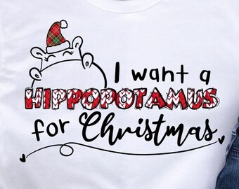 May include: White t-shirt with a red and white plaid hippopotamus wearing a Santa hat and the text "I want a HIPPOPOTAMUS for Christmas."