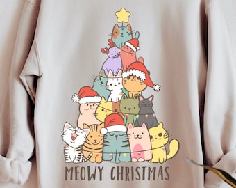 May include: A light gray sweatshirt with a Christmas tree design featuring a variety of cats wearing Santa hats. The text "MEOWY CHRISTMAS" is printed below the tree.