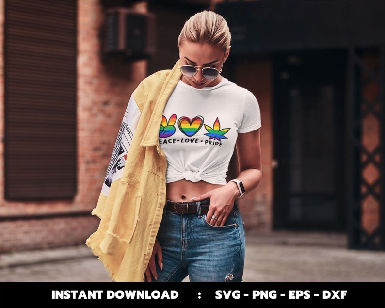 May include: A white t-shirt featuring a rainbow peace sign, heart, and marijuana leaf design. The text "Peace - Love - Pride" is printed below the design.