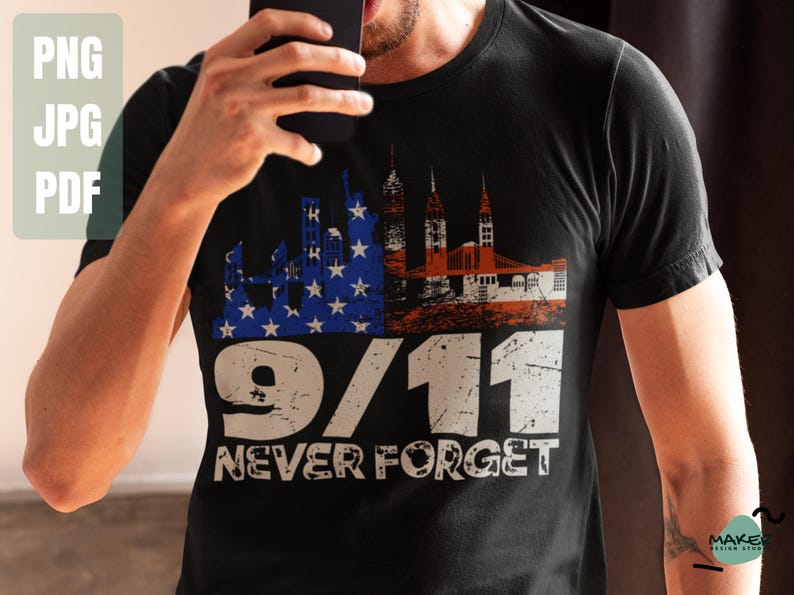 May include: Black t-shirt featuring a distressed graphic design with the text "9/11 NEVER FORGET." The design incorporates the American flag, the Twin Towers, and a bridge. The shirt is a crew neck.