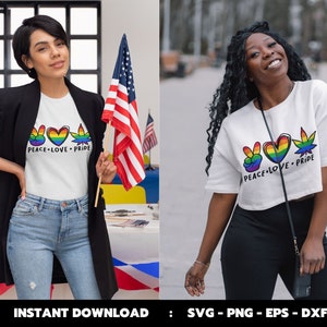 May include: Two women wearing white t-shirts with a peace sign, heart, and marijuana leaf graphic. The text on the shirts reads "Peace Love Pride".