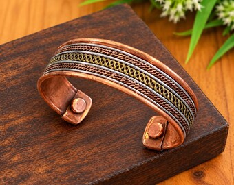 Use the image editing skill to place your first bracelet into the second photo’s wooden setup, preserving its design and colors.