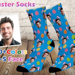 May include: A pair of blue socks with a colorful Easter egg pattern. The socks feature bunny ears and a repeated image of a person's face. The text "20+Colors 1~5 Face" is displayed below the socks.