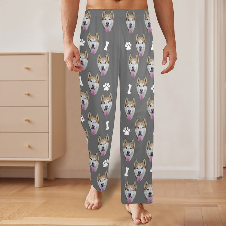 Peut inclure: Pantalon de pyjama gris avec un motif r&eacute;p&eacute;t&eacute; de visage de chien, d'os et d'empreinte de patte.