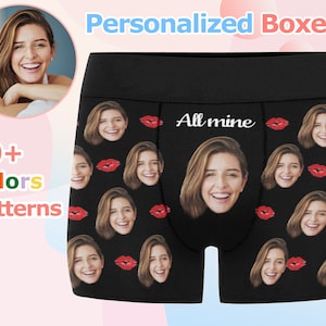 May include: Black boxer shorts with a repeated pattern of red lips and faces. The text "All mine" is printed in white on the waistband.