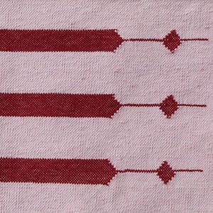 Puede incluir: Un textil tejido rosa y burdeos con un patr&oacute;n de rayas. Las rayas burdeos tienen un dise&ntilde;o geom&eacute;trico con formas de diamante. El textil es probablemente una alfombra o una tela decorativa.