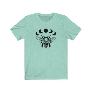 May include: A light blue t-shirt with a black bee and five crescent moons graphic print.
