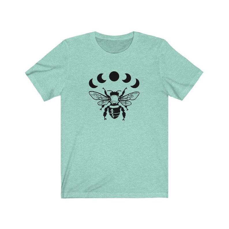 May include: A light blue t-shirt with a black bee and five crescent moons graphic print.