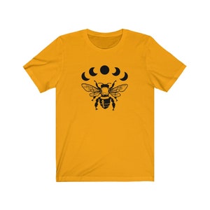May include: A yellow short-sleeved t-shirt with a black bee and five crescent moons graphic print.
