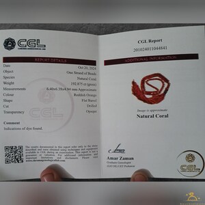 May include: A gemological report for a strand of natural coral beads. The report details the object's measurements (6.40x6.38x4.94 mm), color (reddish orange), and shape (flat barrel). The report also includes an image of the coral.