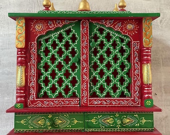 May include: A small, hand-painted wooden temple with a red base, green doors, and gold accents. The doors have a lattice design and the temple has a drawer.