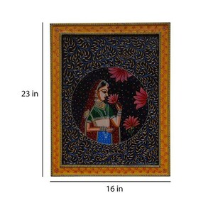 May include: A framed painting depicting a woman in traditional Indian attire, holding a flower. The painting is set against a dark blue background with intricate floral patterns. The frame is yellow with red and gold accents. The painting measures 40.6 cm by 58.4 cm.