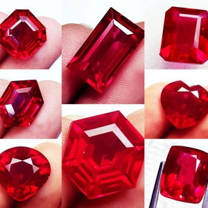 May include: A collection of eight faceted red gemstones in various shapes, including hexagonal, rectangular, heart, and pear cuts. Each gemstone displays a vibrant, deep red color with clear internal facets that reflect light across the surfaces.