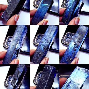 May include: A rectangular, elongated mineral specimen featuring a deep blue and black color palette with a rough, textured surface. The object displays varying shades of indigo and navy, with some areas showing a lighter, translucent blue glow.