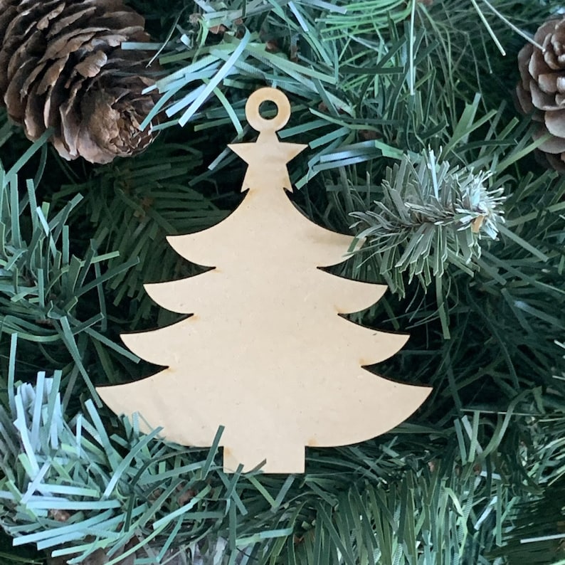 May include: A wooden Christmas tree ornament with a hole at the top for hanging. The ornament is unpainted and ready to be decorated.