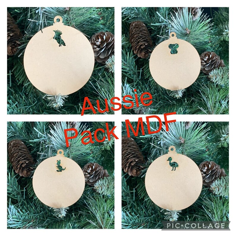 May include: Four wooden Christmas ornaments with Australian animal cutouts. The ornaments are round and have a hole at the top for hanging. The animals are a kookaburra, a koala, a kangaroo, and an emu. The ornaments are labeled "Aussie Pack MDF".