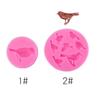 Può includere: Due stampi in silicone rosa per cuocere dolcetti a forma di uccello. Lo stampo più piccolo ha un uccello, mentre lo stampo più grande ne ha sette.