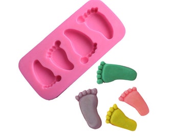 May include: Pink silicone mold with four baby foot shapes. Four colorful baby foot shapes are shown next to the mold.