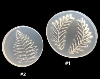May include: Two clear silicone molds for resin casting. One mold features a single fern leaf design, while the other mold features two fern leaves. The molds are labeled #1 and #2.