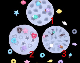 May include: Three silicone moulds for making resin crafts. The moulds are shaped like circles and contain various shapes, including hearts, stars, and ice cream cones. The moulds are shown with small resin pieces in the shapes of strawberries, hearts, stars, and ice cream cones.