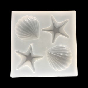May include: A white silicone mould with four cavities shaped like seashells and starfish. The mould is designed for making resin crafts.