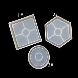May include: Three silicone moulds for resin casting. The moulds are numbered 1, 2, and 3. Mould 1 is a square with a cross design. Mould 2 is a hexagon with a cross design. Mould 3 is a circle with a ring design.