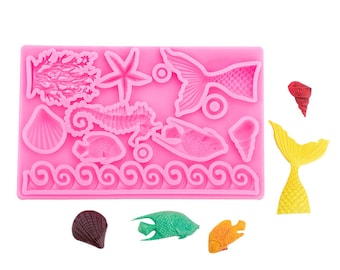 May include: Pink silicone mold with various sea-themed shapes, including a mermaid, seahorse, starfish, seashells, and fish. The mold is designed for making edible decorations for cakes or other desserts.