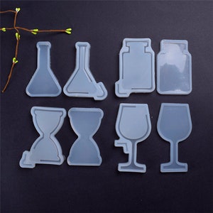 May include: Eight clear silicone molds for resin casting. The molds are shaped like a beaker, a flask, an hourglass, a wine glass, and a bottle.