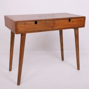 Op de afbeelding: Een houten bureau met twee laden en vier poten. Het bureau is gemaakt van donkerbruin hout en heeft een eenvoudig, modern ontwerp.
