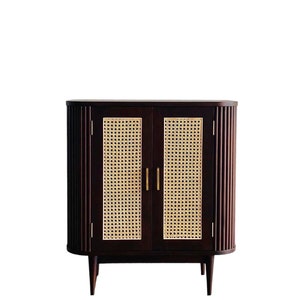 May include: A dark brown wooden cabinet with two doors featuring woven cane panels. The cabinet has a curved top and bottom and sits on four slender legs.
