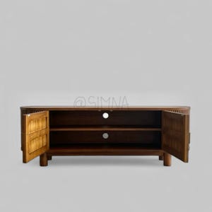 May include: A dark brown wooden entertainment center with two doors that are open, revealing two shelves. The entertainment center has a rounded front edge and sits on four legs.