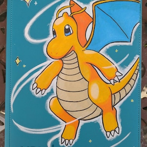May include: A teal case featuring a hand-painted illustration of a yellow and orange dragon with blue wings. The dragon is surrounded by white swirls and yellow stars. The word "vaultx" is visible in the bottom left corner.