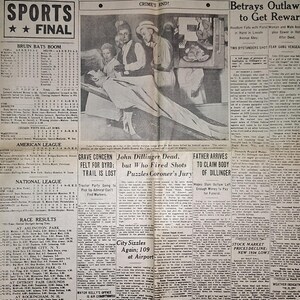 Puede incluir: Un periódico antiguo Chicago Daily News del 23 de julio de 1934, con los titulares Girl Tricks Dillinger y U.S. Agents Slay Gunman at Movie. La portada incluye fotografías en blanco y negro, resultados deportivos y varios artículos de noticias.