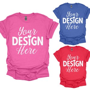 May include: Three t-shirts in different colors: pink, blue, and red. Each shirt has the text "Your Design Here" printed on the front in white.
