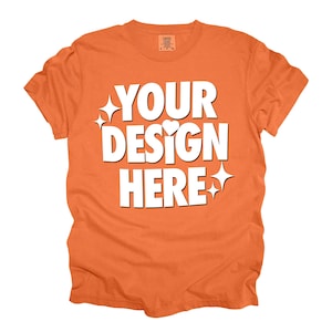 May include: Orange t-shirt with the text "YOUR DESIGN HERE" in white. The text is surrounded by small white stars and hearts.