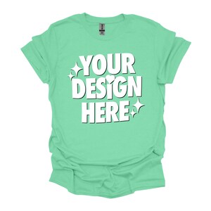 May include: A light green t-shirt with the text "YOUR DESIGN HERE" in white. The text is styled with a heart and stars.