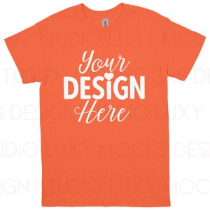 May include: Orange t-shirt with the text "Your DESIGN Here" in white script and block letters. A small white heart is between the words "DESIGN" and "Here". The t-shirt is a crew neck style.