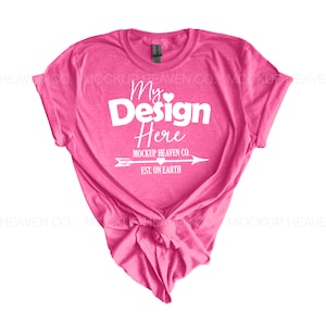 May include: Pink t-shirt with a knotted front and the text "My Design Here" with a small heart and arrow graphic. The text below the design reads "Mockup Heaven Co. Est. On Earth".