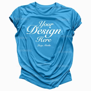 May include: A light blue t-shirt with the text "Your Design Here" and the words "Luxy Mocks" printed on the front.