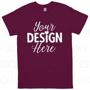 May include: A maroon t-shirt with the text "Your DESIGN Here" in white script. The design includes a small heart above the word "DESIGN". The shirt is a short-sleeved crew neck.