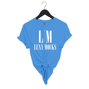 May include: A light blue t-shirt with a white graphic design that says "LM LUXY MOCKS".