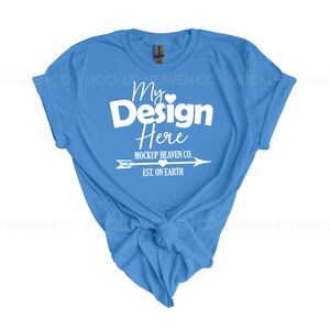 May include: A light blue t-shirt with a white design that says "My Design Here" with a small heart and arrow. The text below the design says "Mockup Heaven Co. Est. On Earth".
