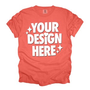 May include: Coral colored t-shirt with the text "YOUR DESIGN HERE" in white.