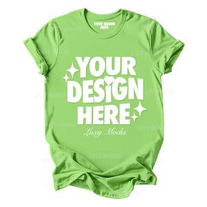 May include: A bright green t-shirt with the text "YOUR DESIGN HERE" in white. The text is centered on the shirt and is surrounded by small white stars and a heart.