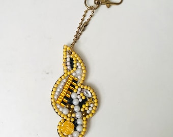 Handmade treble clef Keyring set in resin with yellow and white colours