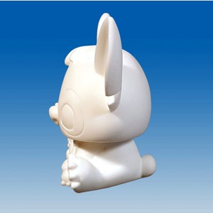 May include: White ceramic figurine of a cartoon animal with large ears and a sitting pose.